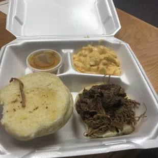 Beef brisket sandwich meal with side of Mac and Cheese and Carolina Gold BBQ sauce