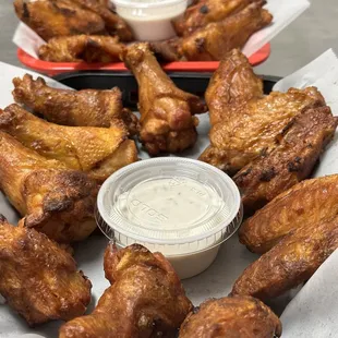 a platter of chicken wings and dipping sauce