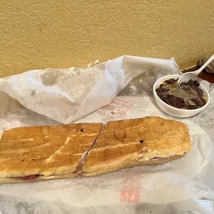 a sub sandwich and a bowl of peanut butter