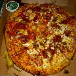 Hawaiian pizza with ham, spicy sausage, pineapple, and pepperoni