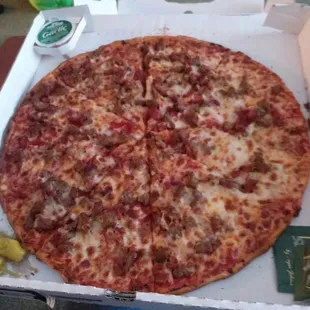 Thin crust pizza with spicy Italian sausage, ground beef, and bacon