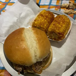 A colossal pork sandwich with smoked corn on the cob. 2 thumbs up!!