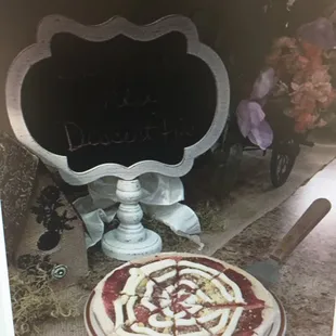 a pizza on a table in front of a chalkboard