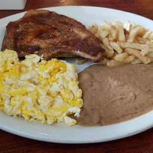 Pork Chop, Scrambled Eggs, Potatoes, and Refried Beans