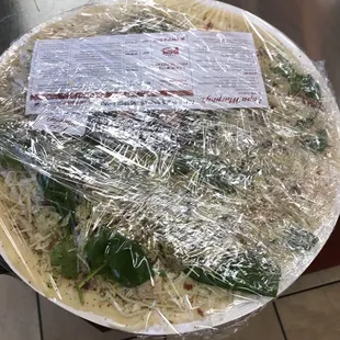 a pizza wrapped in plastic wrap