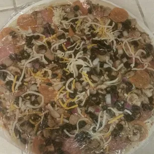 a pizza covered in plastic wrap