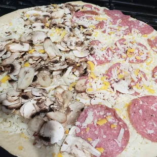 pizza at home unwrapped, large half salami, half mushroom