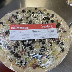 a pizza covered in plastic wrap