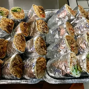 a tray of wrapped sandwiches
