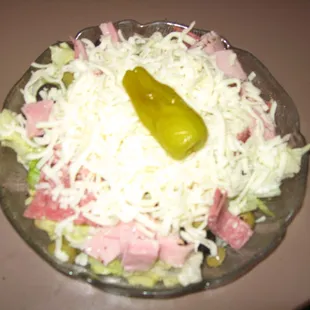 Antipasto Salad with lettuce, with Italian Deli meats, cheese and a pepper.