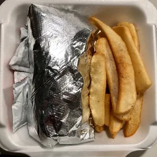 Gyro and fries in the take out container.