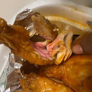 a person holding a piece of chicken