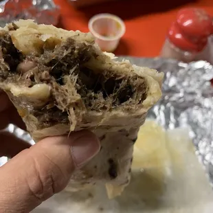 a hand holding a burrito