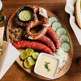 a plate of hotdogs, pretzels, and a beer