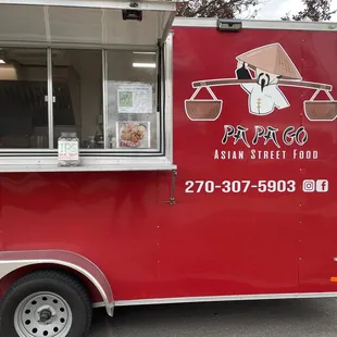 a red food truck parked in a parking lot