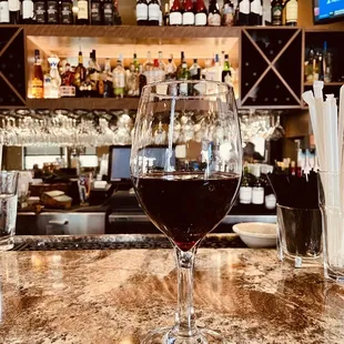 a glass of wine on a bar