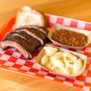 a plate of ribs, macaroni and cheese