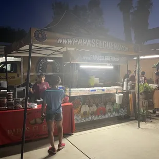 This is where you order at red table and on other side you pick up your food. Nice set up in someone's back yard.