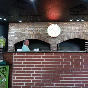 a brick oven with a clock above it