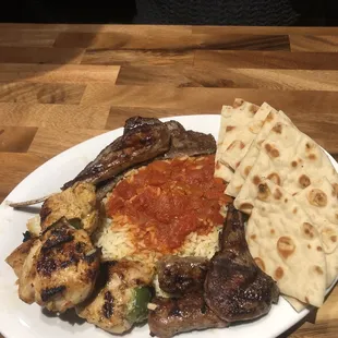Mediterranean Mezza platters includes chicken kabobs lamb chops gyro meat homemade chevapi sausage rice pita bread and Greek salad