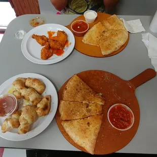 a table with a pizza and other food items