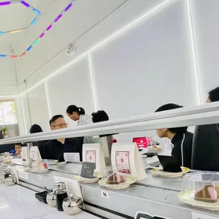 Remodeled all white dining room with conveyor and modern lighting