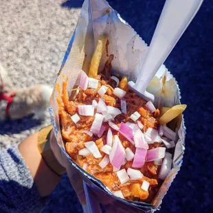 a person holding a basket of fries