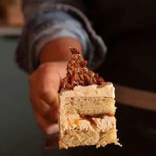 a person holding a piece of cake