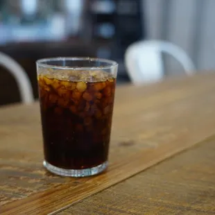 a glass of iced coffee on a wooden table