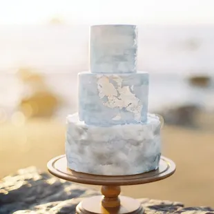 a three tiered cake on a wooden stand