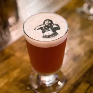 Chester Copperpot. Brandy, Pino Noir, apertif amaro, grenadine, lime, bitters, egg white. Rice paper stencil float.