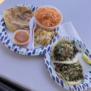 Two carne asada tacos a papusa and rice
