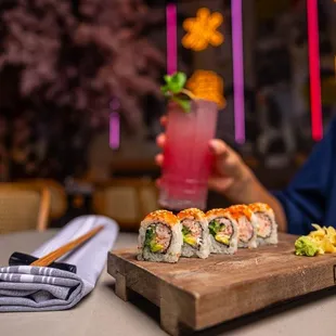 a person holding a glass of sushi