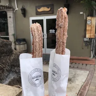 a hand holding two churros