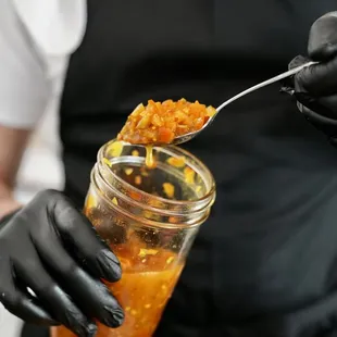 a person holding a jar of food