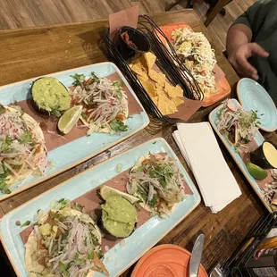 a variety of tacos on plates