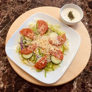 House salad with lettuce, onions, green peppers, tomatoes, cheddar cheese.