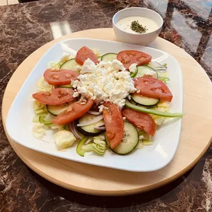 Greek salad with lettuce, green peppers, tomatoes, cucumbers, pepperocini and feta cheese.