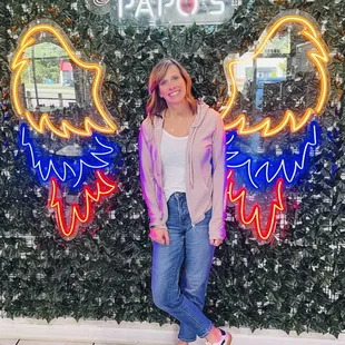 a woman standing in front of a neon sign