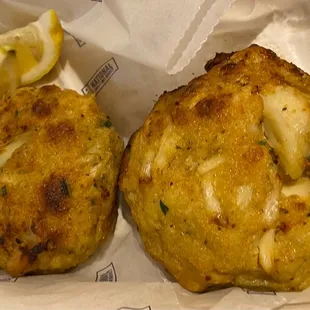 two crab cakes in a paper bag