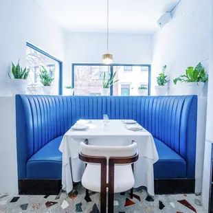a blue booth with a white table and chairs