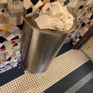 The hallway trash outside the men and women bathroom