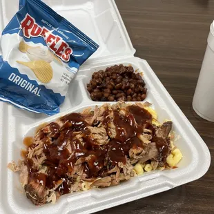 Pulled pork bowl made into a meal with chips, beans, and a drink