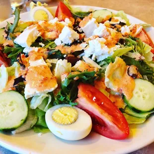 a plate of salad with hard boiled eggs, tomatoes, cucumbers, and hard boiled eggs