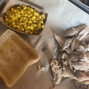 a pulled pork sandwich and corn