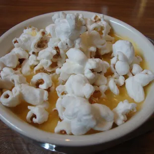Beer Cheese Soup with popcorn on top, close-up.