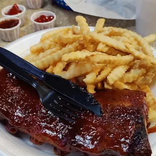 a plate of ribs and french fries