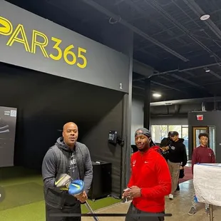 two men standing in front of the par365 booth