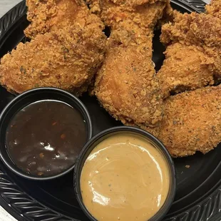 a plate of fried chicken with dipping sauce