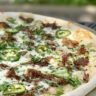 Las Carnitas. Carnitas, Red Onions, Sliced Jalapeños, Fresh Cilantro, Tequila Cream Sauce &amp; Mozzarella.
